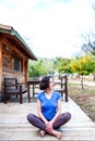 A woman is sitting on the porch of an old wooden house