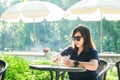 Woman sitting and pouring hot tea into glass in the garden Royalty Free Stock Photo