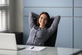 Woman sitting put hands behind head enjoy repose during workday