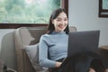 Woman is sitting and relaxing on the couch, Relax in the living room at home on holiday, Woman using laptop to relax in living Royalty Free Stock Photo