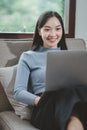 Woman is sitting and relaxing on the couch, Relax in the living room at home on holiday, Woman using laptop to relax in living Royalty Free Stock Photo
