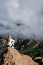 Woman sitting on a rock with the amazing view of Roque Nublo in Gran Canaria