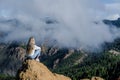 Woman sitting on a rock with the amazing view of Roque Nublo in Gran Canaria