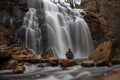 woman sitting on a rock in front of Mackenzie Falls