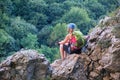 Woman sitting on rocks and admiring the view from Casa Zmeului via ferrata route in Padurea Craiului mountains, Romania.