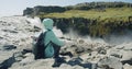 Woman sitting on rocks enjoying powerful Detifoss waterfall and basalt canyon in Iceland Royalty Free Stock Photo