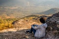 A woman sitting on rocky mountain looking out at scenic natural view and beautiful blue sky Royalty Free Stock Photo