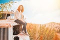 Woman sitting on rusty old classic truck. Royalty Free Stock Photo