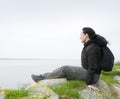 Woman sitting on sea cliff