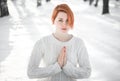 Young woman sitting and praying in winter forest Royalty Free Stock Photo