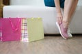 A young woman dressing a pair of light pink boots on a store background. Glamorous girl choosing shoes in a shop. Royalty Free Stock Photo