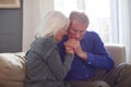 Woman Sitting On Sofa Comforting Senior Man Suffering With Mental Health Issues At Home Royalty Free Stock Photo