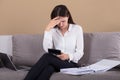 Woman Sitting On Sofa Holding Calculator Royalty Free Stock Photo