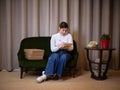 woman sitting on a sofa next to stacked packages writing on a notebook Royalty Free Stock Photo