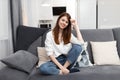 woman sitting on the sofa with pillows comfortable apartment