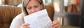 Woman sitting on sofa and reading instructions for medical use of pills Royalty Free Stock Photo