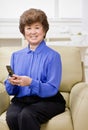 Woman sitting on sofa text messaging Royalty Free Stock Photo