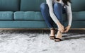 Woman sitting on sofa to wearing high heels Royalty Free Stock Photo