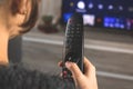 Woman sitting on sofa with TV remote control in front of TV and watch streaming services concept photo Royalty Free Stock Photo