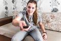 Woman sitting on sofa with TV remote switching channels and watching TV Royalty Free Stock Photo