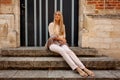 Woman sitting stairs medieval Romanesque door evening sun Royalty Free Stock Photo