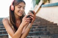 Woman sitting on steps outdoors while listening music Royalty Free Stock Photo