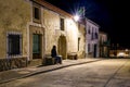 Woman sitting on a stone bench in an ancient village at night, Royalty Free Stock Photo