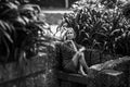 A woman sitting on a stone bench in an old park. Royalty Free Stock Photo