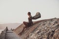 Woman sitting on stones in Monolithos castle in Rhodes, Greece