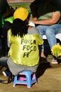 Woman sitting on a stool with the words on the back: `Strength, focus, Faith, focus`