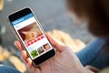 woman sitting in the street holding her smartphone with influencer profile