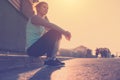 Tired woman sitting on the street, resting after nice workout. Urban running. Vintage colors Royalty Free Stock Photo