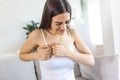 Woman sitting with strong chest pain and hands touching her chest while having trouble at home, Heart attack or heart failure Royalty Free Stock Photo