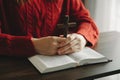 Woman sitting and studying the scriptures.The wooden cross in the hands. Christian education concepts The Holy Scriptures open Royalty Free Stock Photo