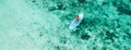 Woman sitting on sup board and enjoying coral reef