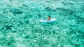 Woman sitting on sup board and enjoying coral reef