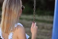 Serene Woman Enjoying the Park Swing on a Sunny Summer Day