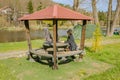 Woman sitting at table in gazebo near the Berunka River in early spring. Czech Royalty Free Stock Photo