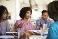 Woman sitting at the table holding hands with her young adult children saying grace before dinner Royalty Free Stock Photo
