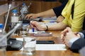 Woman, sitting at table during meeting or negotiations, holds pen and reads paper document Royalty Free Stock Photo