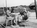 Woman sitting at table outside with three dogs Royalty Free Stock Photo