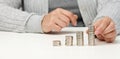 Woman is sitting at the table and a stack of coins on the table. Calculation of expenses and income, subsidy, tax