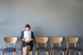 Woman is sitting to review the documents.