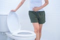 A woman is sitting on toilet with diarrhea or constipated pain c