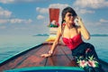 Woman sitting on traditional thai wooden long tail boat