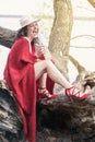 Woman sitting on tree with bottle of champagne