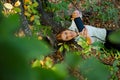 Woman sitting in a tree talking on her smart phoneWoman climbed in a tree taking a selfportrait