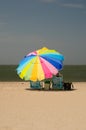 Woman sitting under colorful umbrella Royalty Free Stock Photo