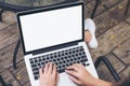 A woman sitting , using and typing on laptop with blank white screen on thigh at outdoor background Royalty Free Stock Photo