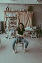 Woman sitting on a viennese chair in the center of potter studio